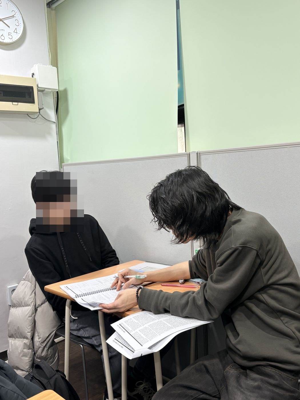 원장이 학생 옆에 앉아 한 명씩 풀이를 짚어 주는 모습