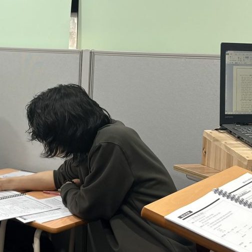 원장이 학생 자리에서 풀이를 확인하는 모습